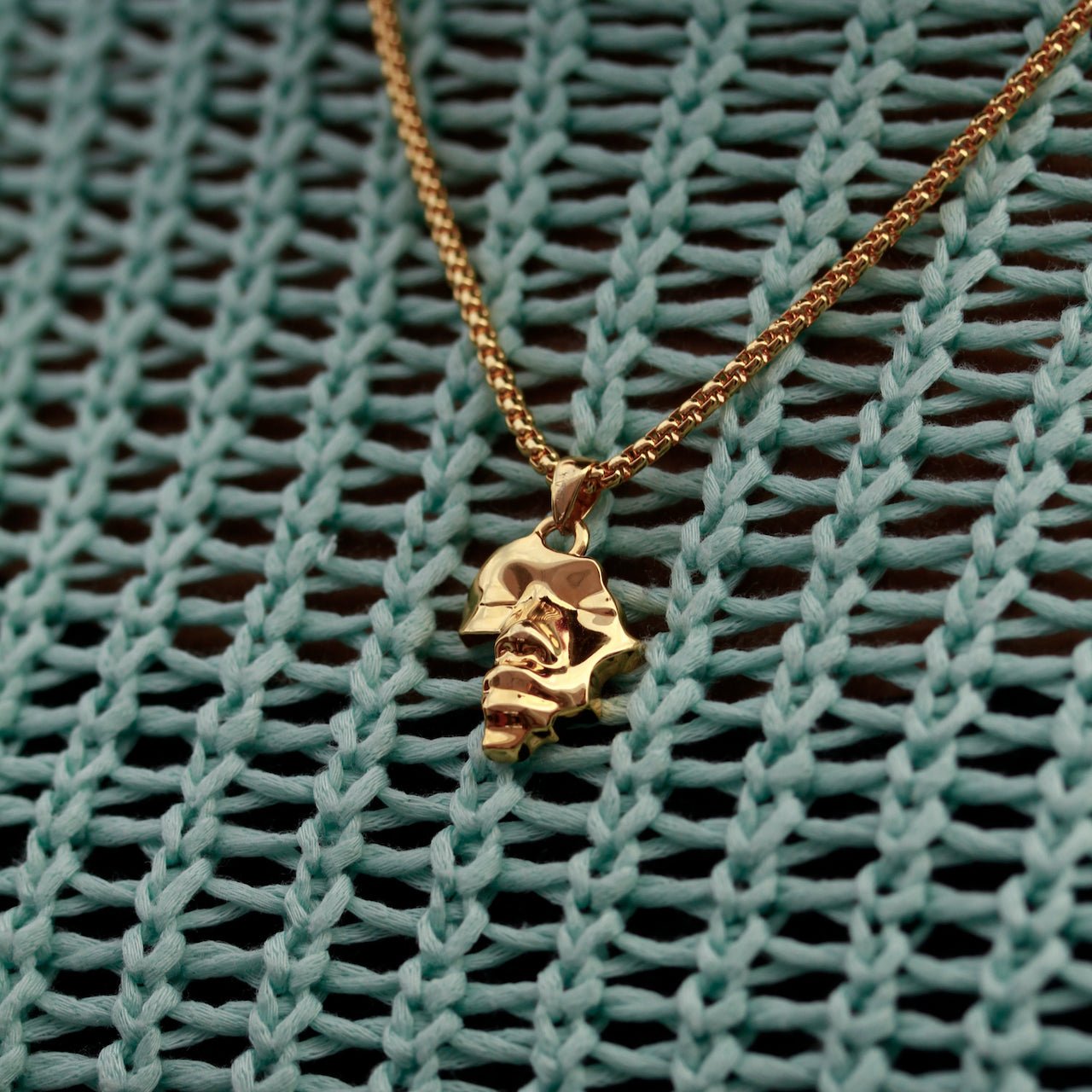 Gold Plated Africa Face Motherland Pendant Necklace with Cowrie Shell from NUJUAL, a black owned jewelry shop for men and women.